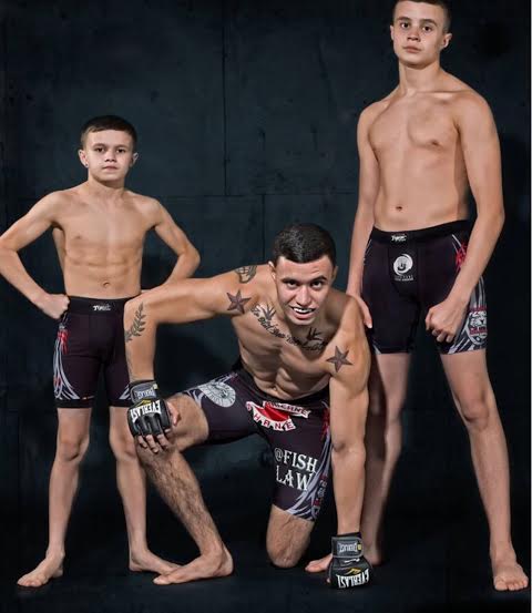 Three MMA fighters posing in Tiger Schulmann's