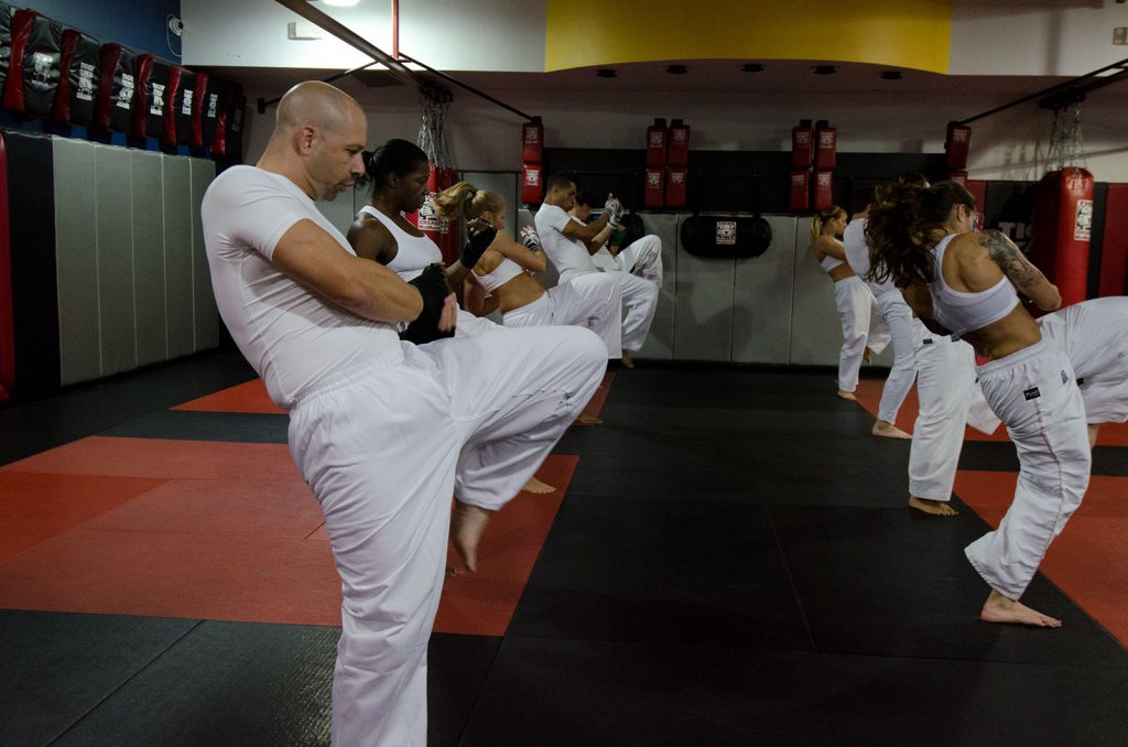 Men and women in white gym outfits training in Tiger Schulmann's in Ramsey