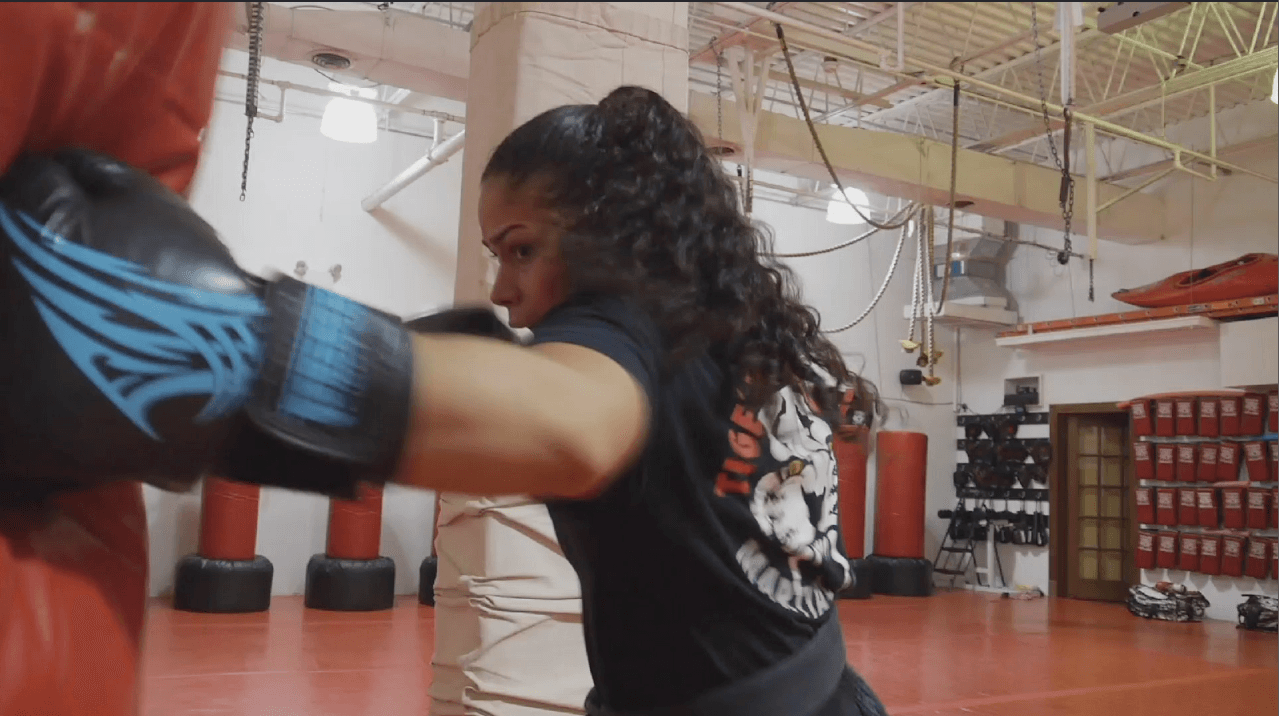 Girl punches a red punching bag