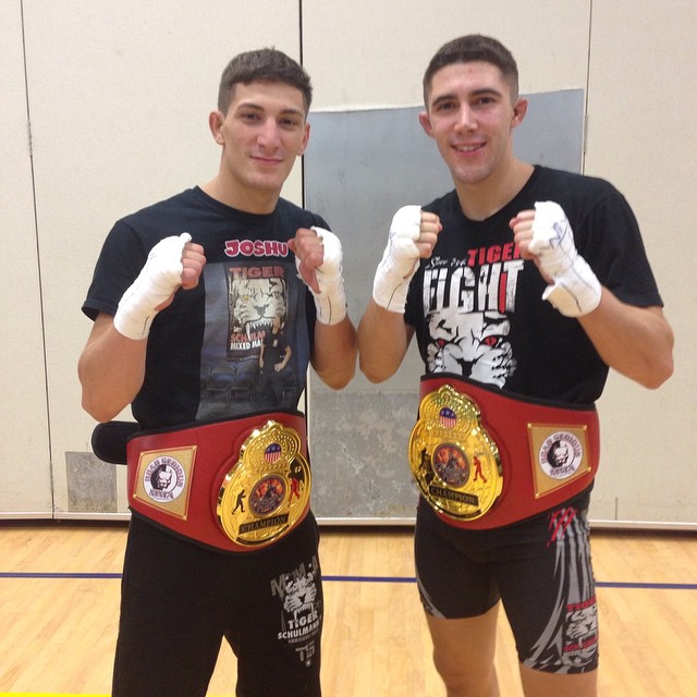 Two Tiger Schulmann's MMA fighters with championship belts in Punching Pose