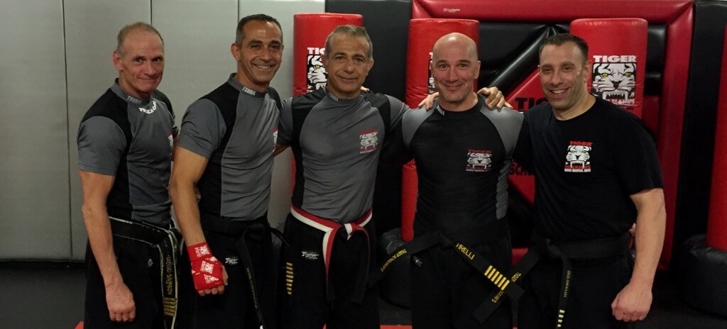 Five MMA fighters posing at Tiger Schulmann's gym