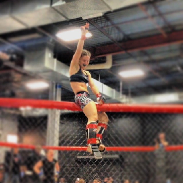 Woman fighter sitting on the ropes Celebrating