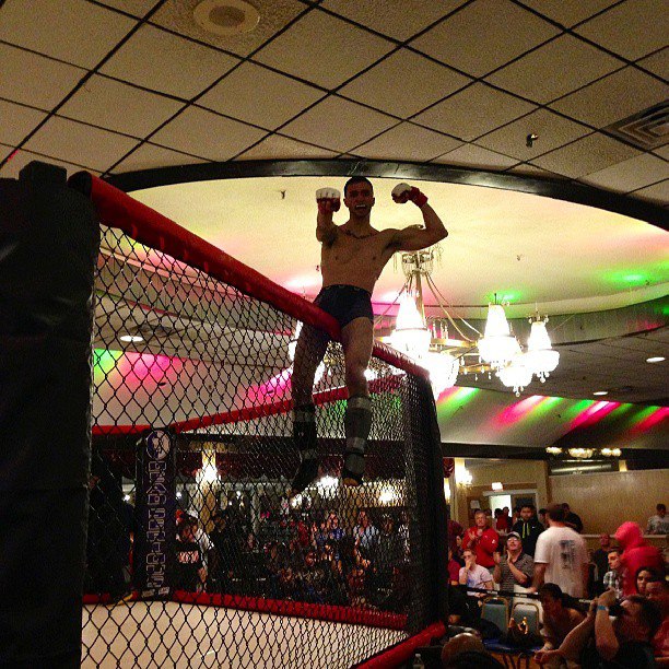 MMA fighter sittingn on top of Octagon Ring