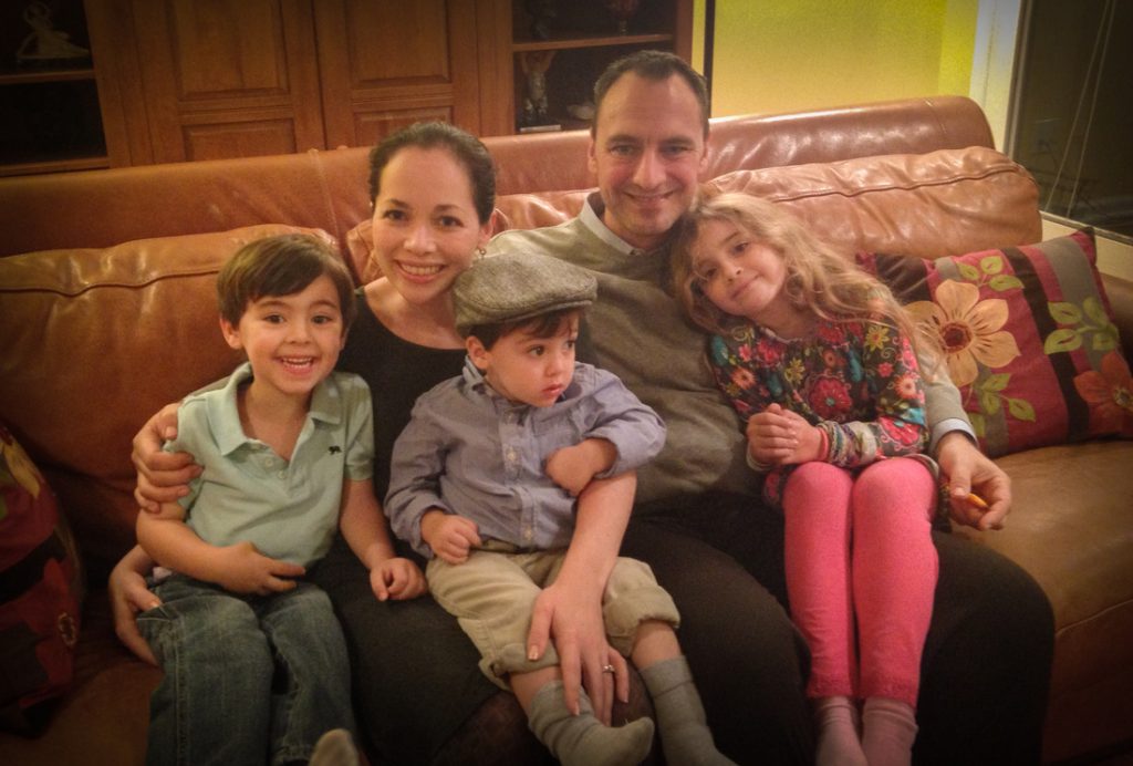 Two parents and three children on a living room couch
