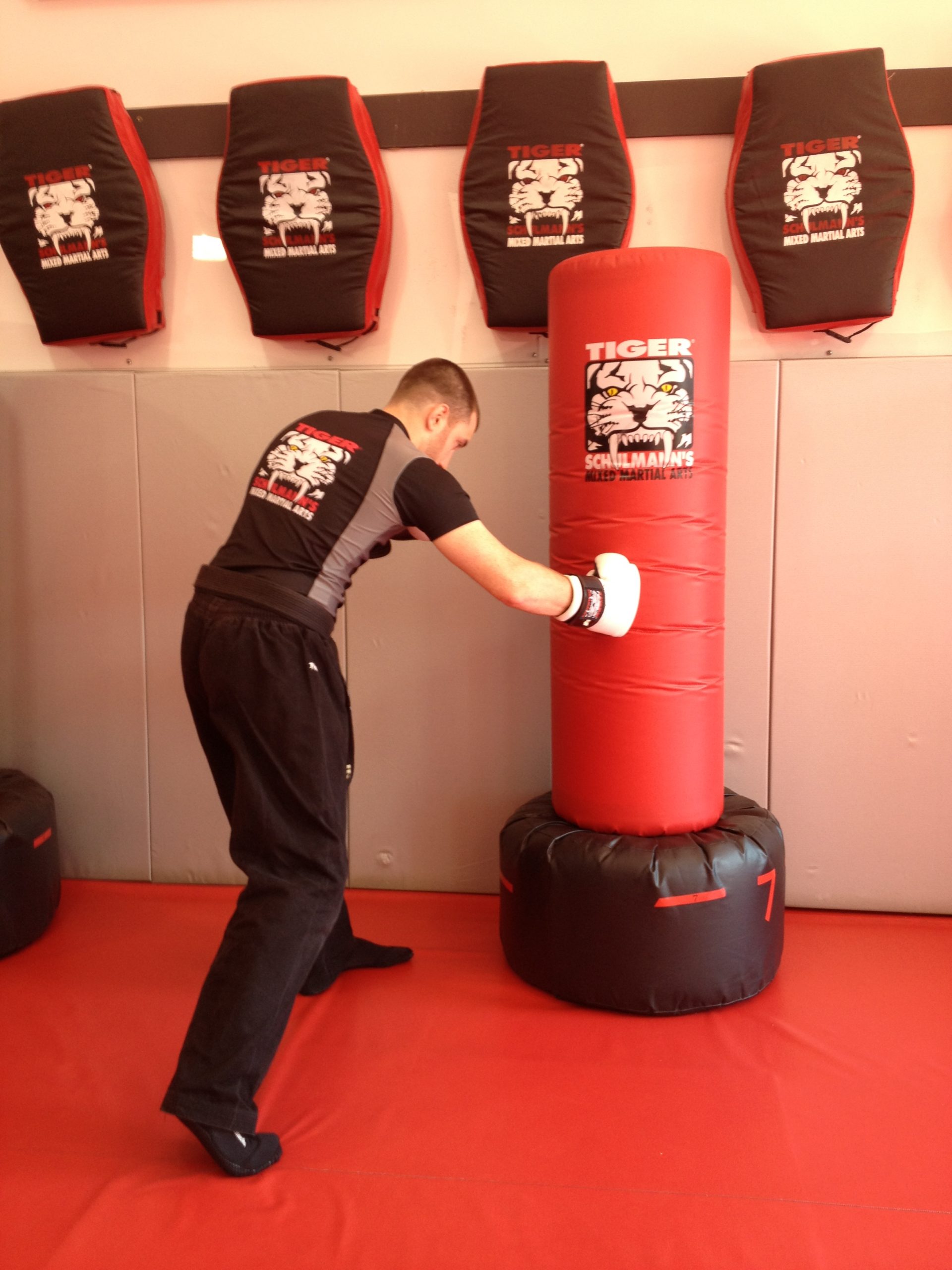 Man fighter Punching a red bag at Tiger Schulmann's Smithtown