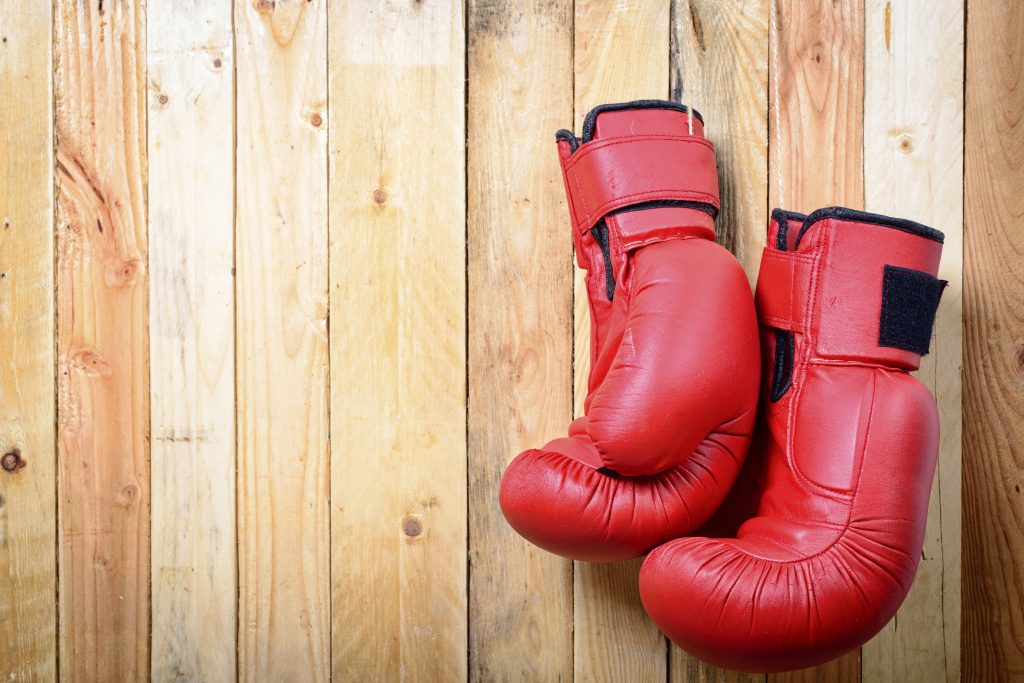 Red Boxing Gloves hanging on the wooden boards