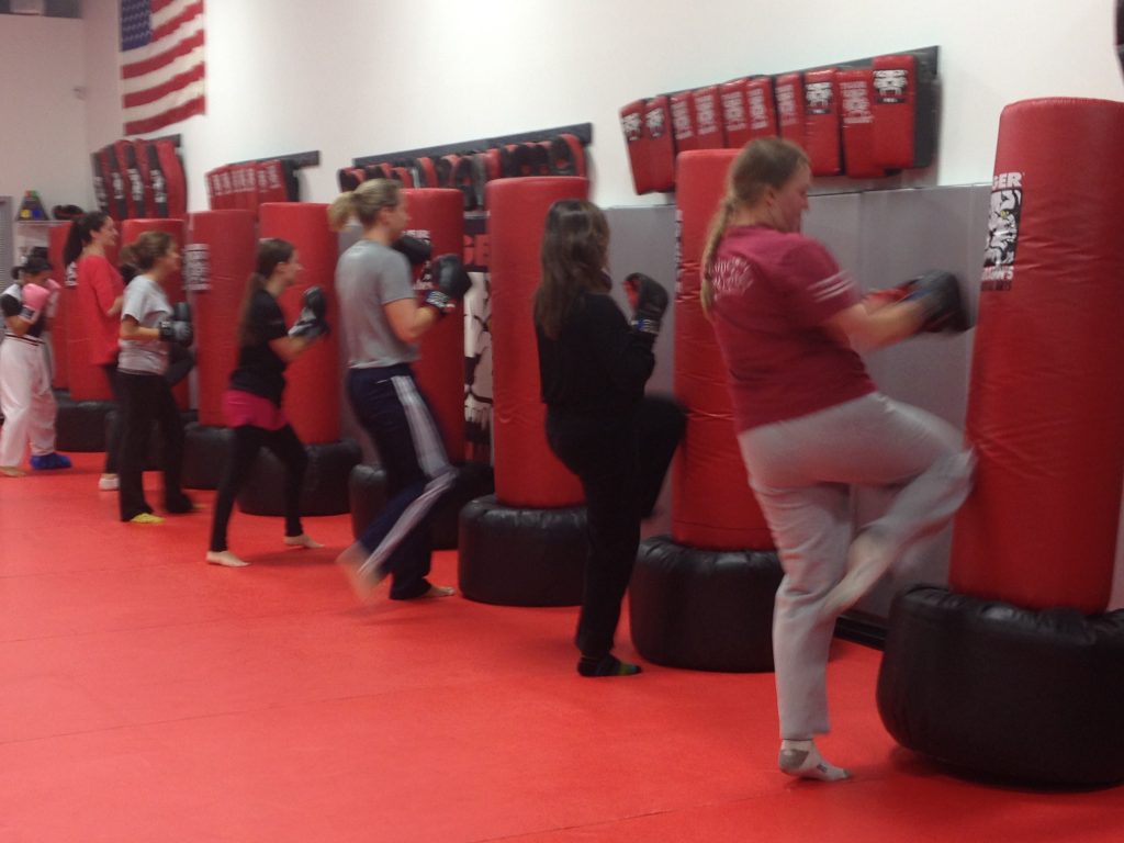 Adult team kickboxing kicking punching bags on the floor at Tiger Schulmann's