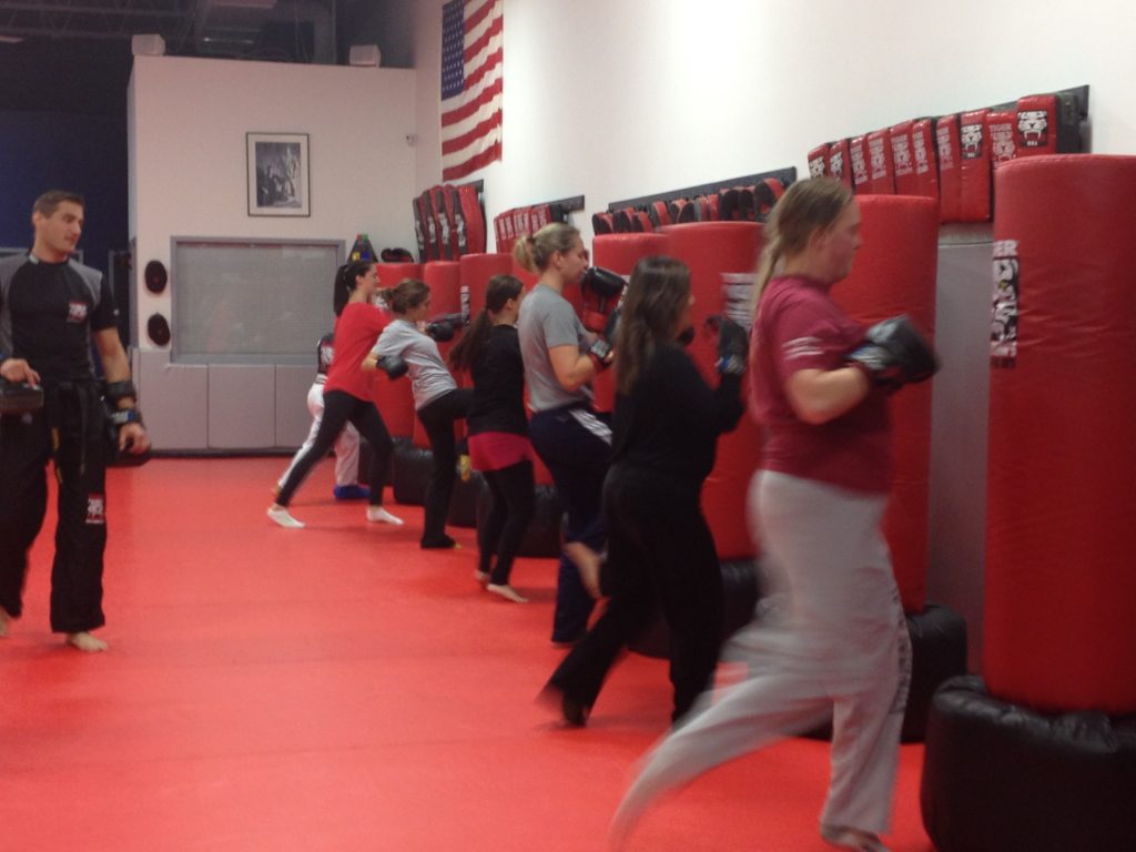 Women team kickboxing training with punching bags at Tiger Schulmann's