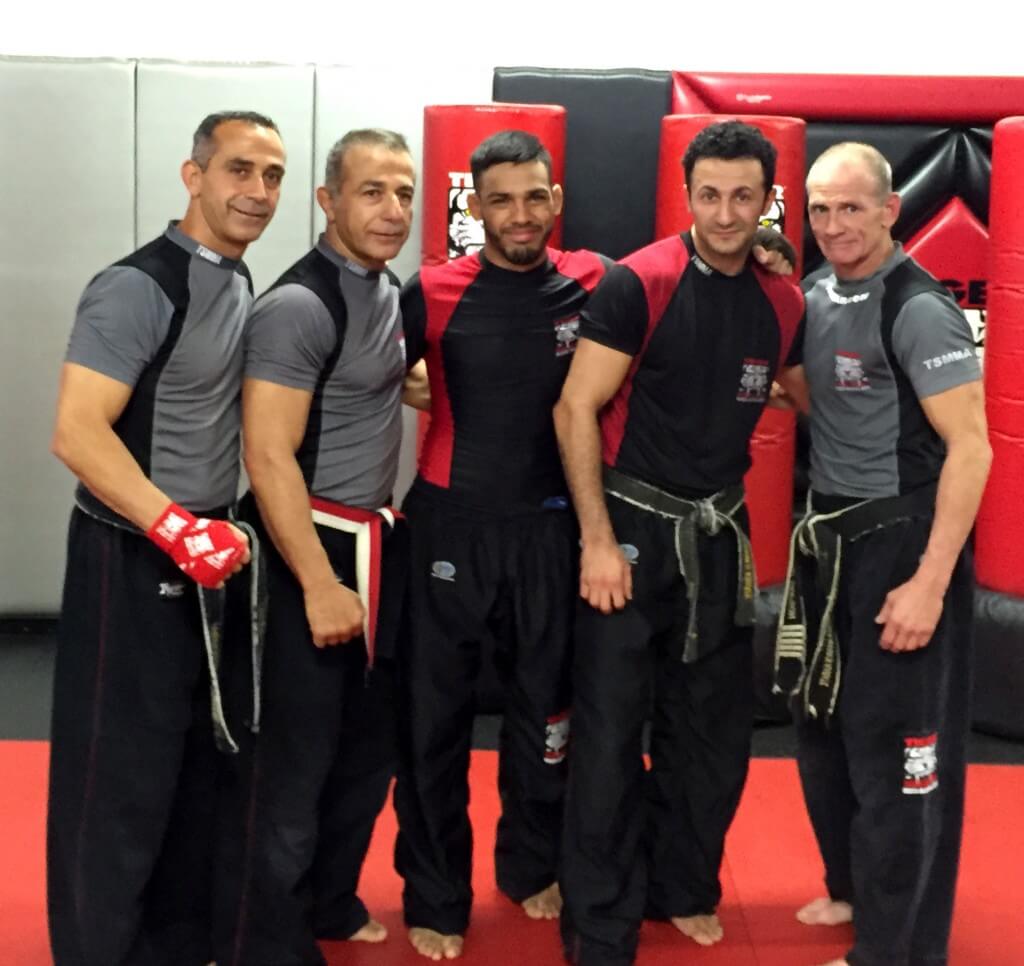 Five MMA fighters posing at Tiger Schulmann's gym