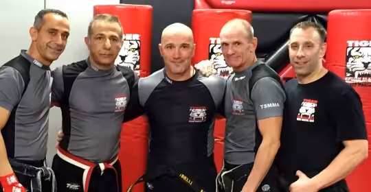 Five MMA fighters posing at Tiger Schulmann's gym