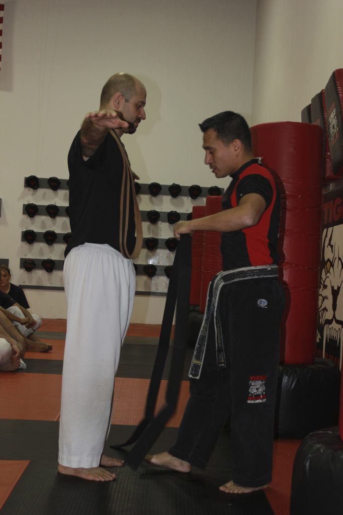 Martial arts master Giving black Belt to a fighter at Tiger Schulmann's Morris Plains
