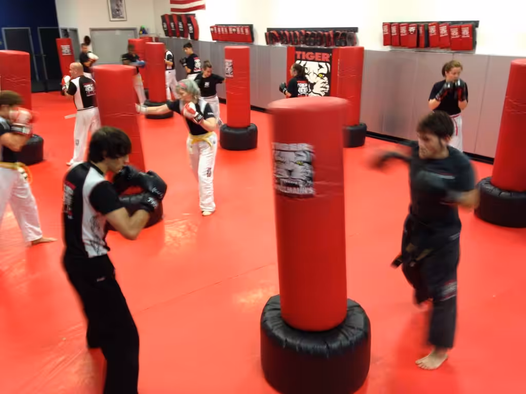 Adult team kickboxing training with punching bags at Tiger Schulmann's