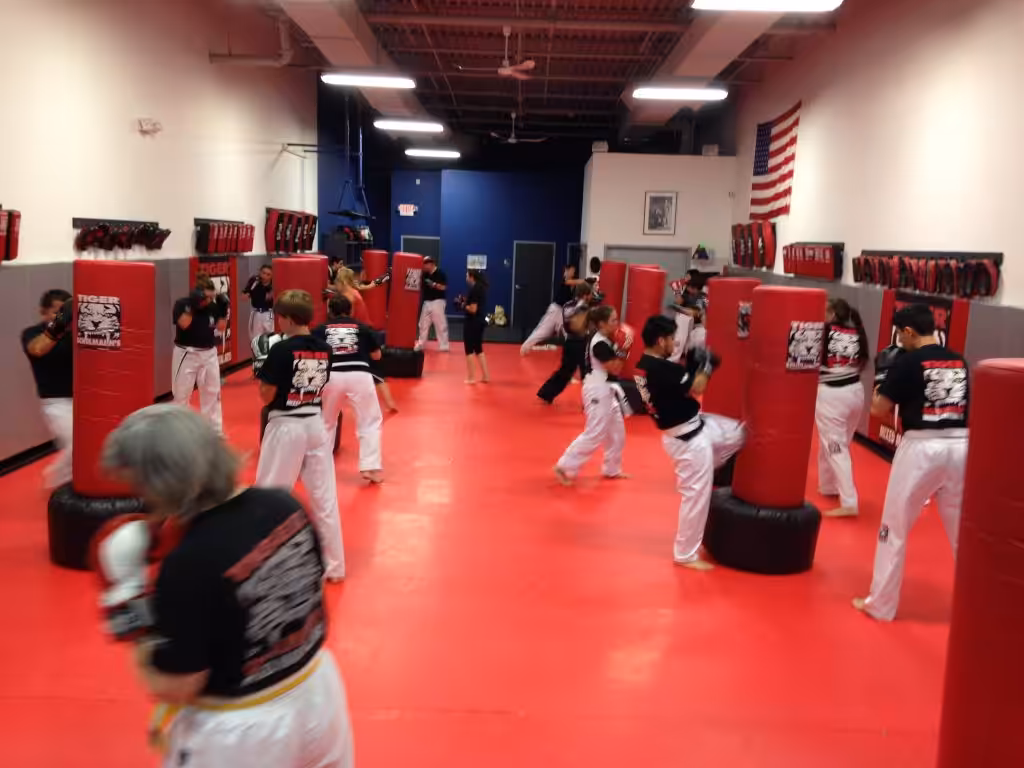 Adult team kickboxing training with punching bags at Tiger Schulmann's