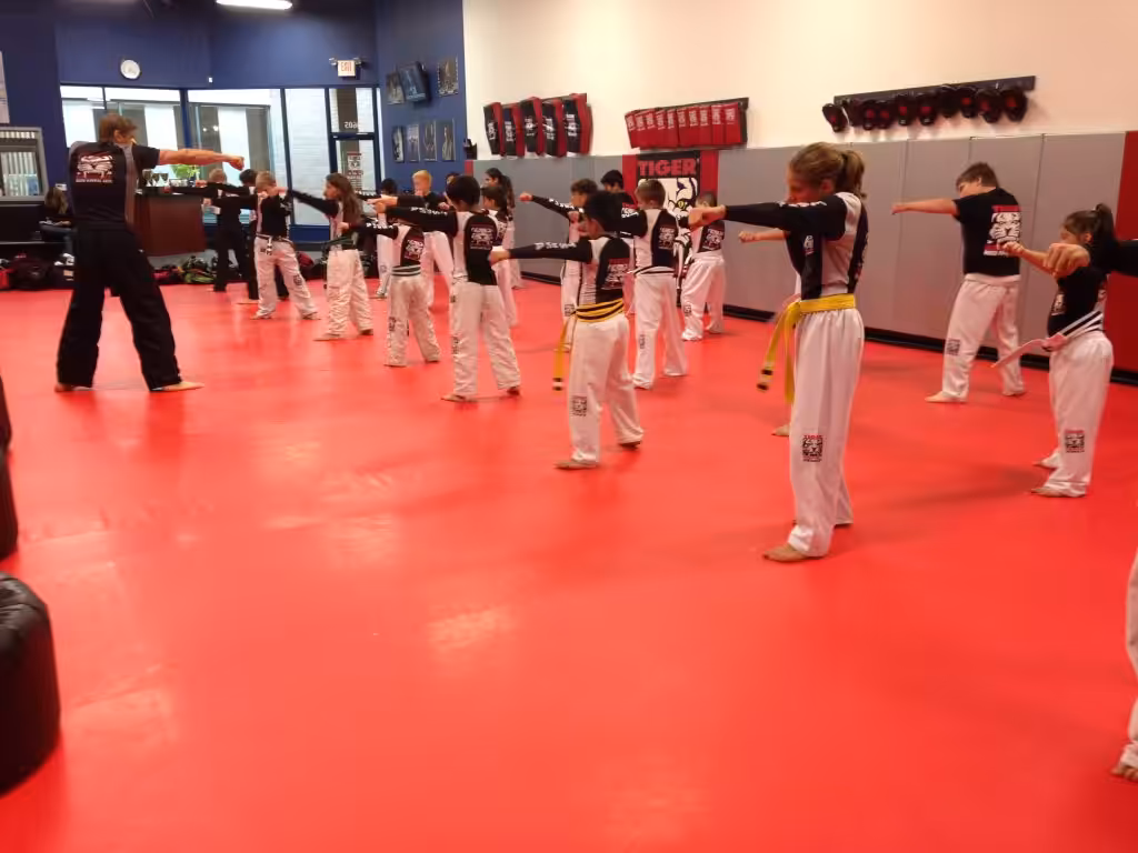 Children exercising Punching with instructor at Tiger Schulmann's Wayne