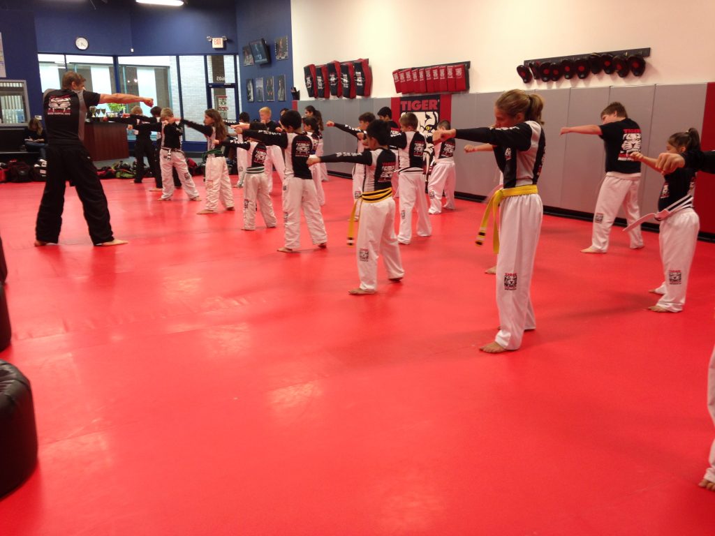 Children exercising Punching with instructor at Tiger Schulmann's Wayne