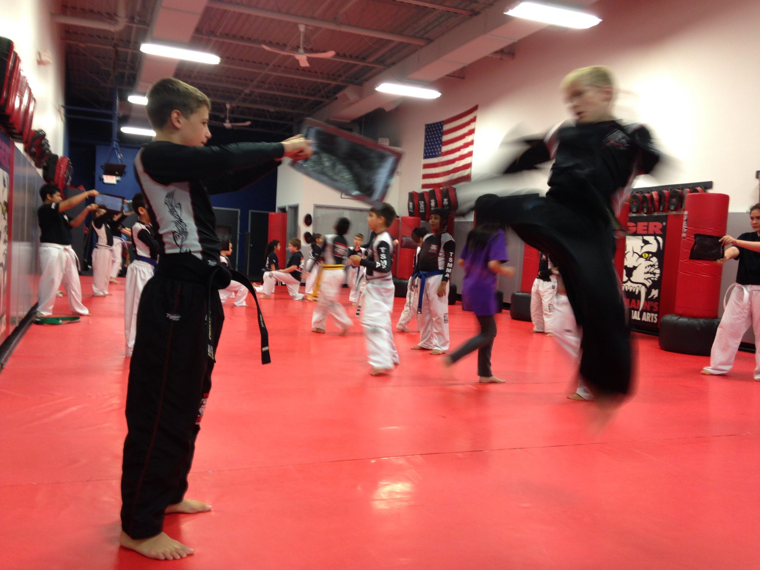 Boy Kicking with other kids training in the gym at Tiger Schulmann's