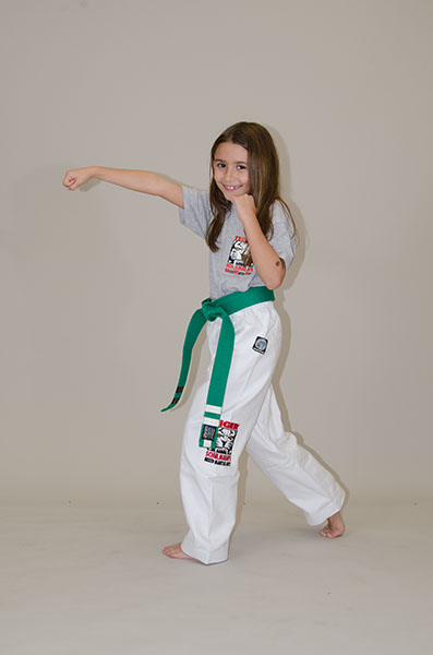 A Girl with green belt wearing Tiger Schulmann's gear smiling and Punching