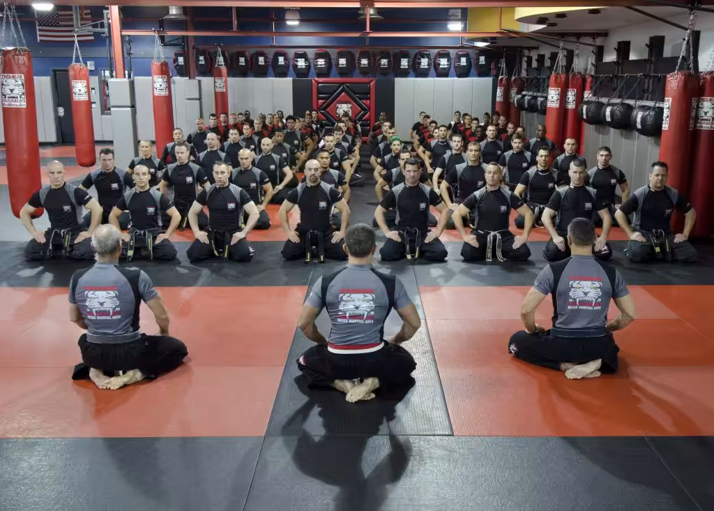 Sitting MMA group with three instructors at Tiger Schulmann's Martial Arts