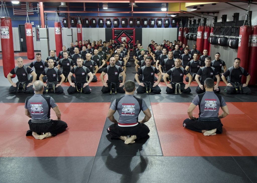 Sitting MMA group with three instructors at Tiger Schulmann's Martial Arts