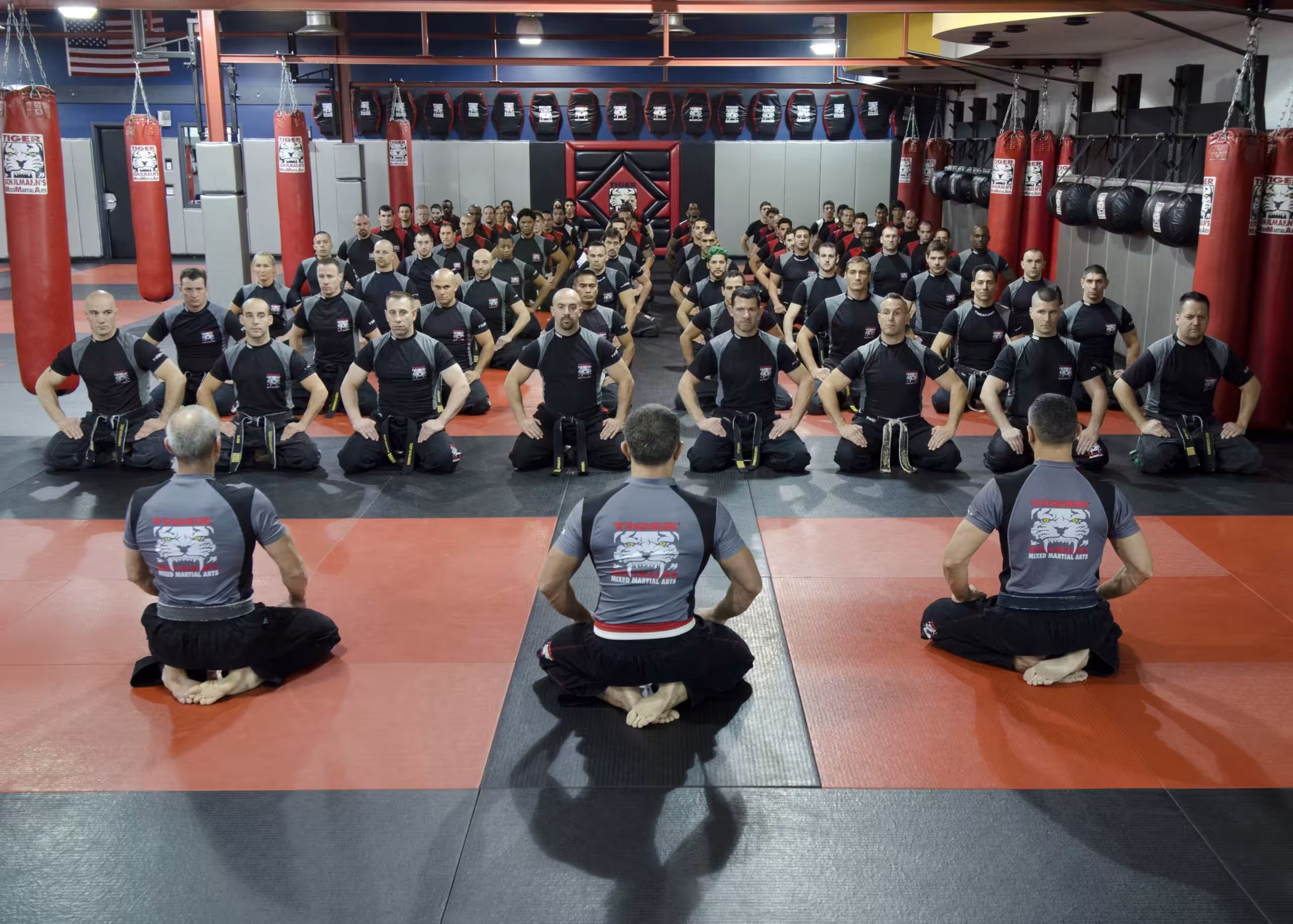 Sitting MMA group with three instructors at Tiger Schulmann's Martial Arts