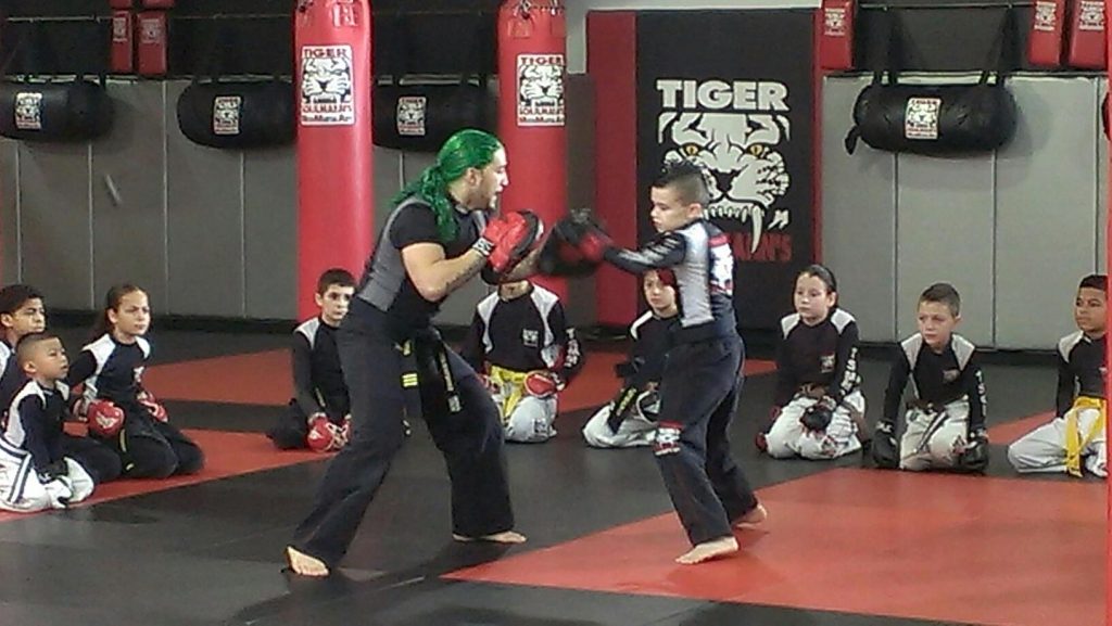 A boy sparring with his instructor with other kids observing in anti bullying commercial