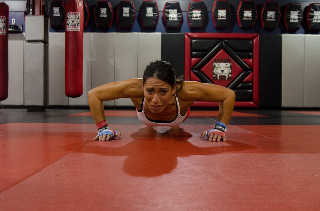 Woman fighter doing Push Ups at Tiger Schulmann's gym