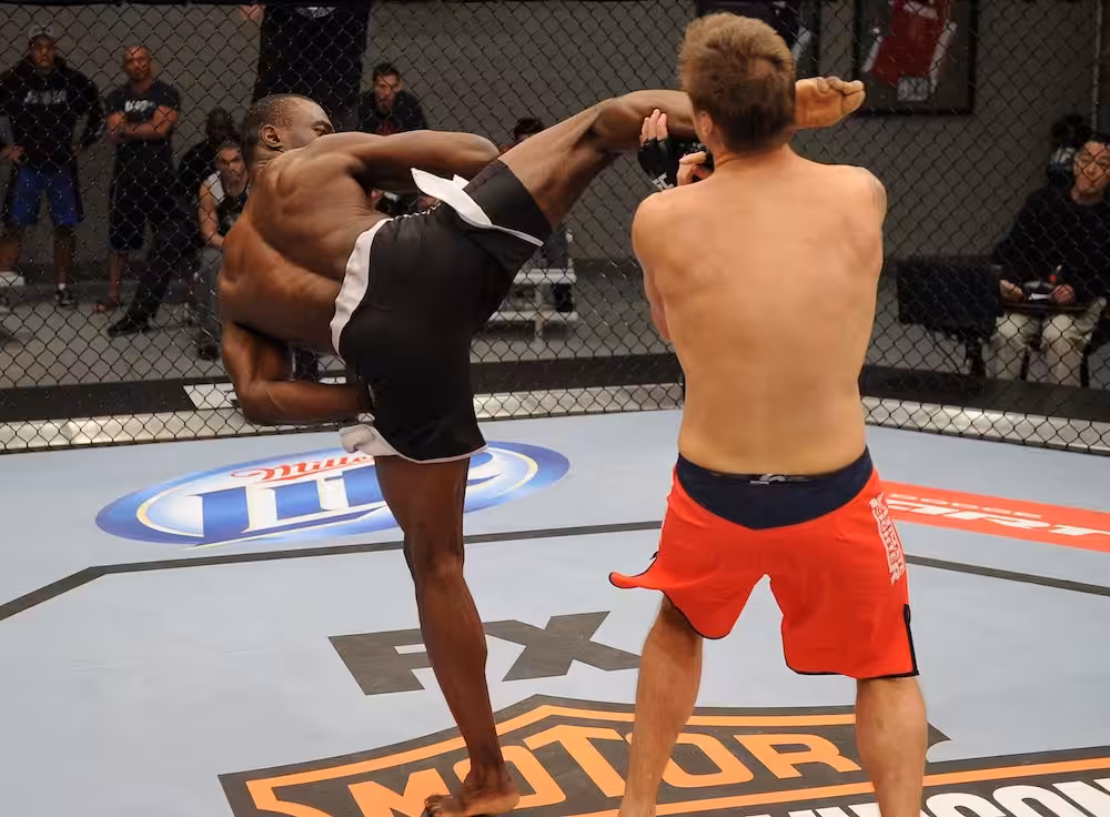 MMA fighter Uriah Hall kicking an opponent in octagon