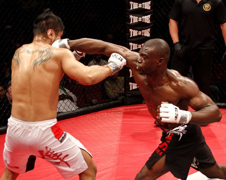 MMA fighter Uriah Hall punching an opponent in octagon