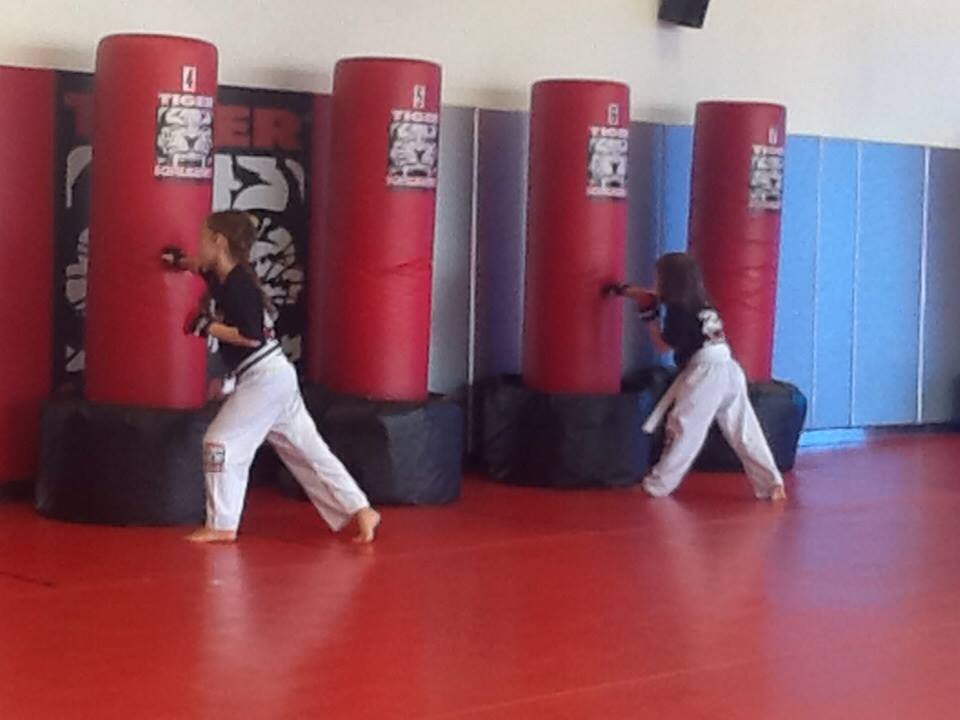 Two Girls Punching bags during kids training at Tiger Schulmann's Abington
