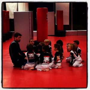 Kids Kneeling on the Floor and listening to instructor at Tiger Schulmann's Abington