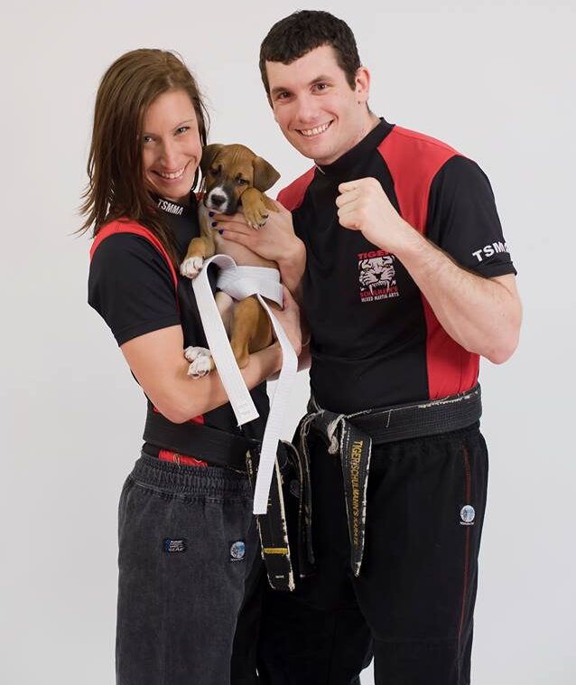 Man and Woman in Tiger Schulmann's outfit with Puppy