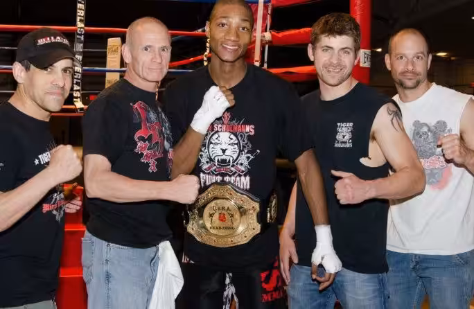 MMA fighter with his championship belt and his 4 Tiger Schulmann's team members