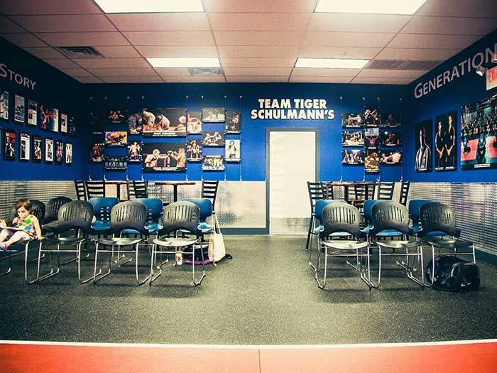 Empty Chairs in a room with blue walls and posters at Tiger Schulmann's