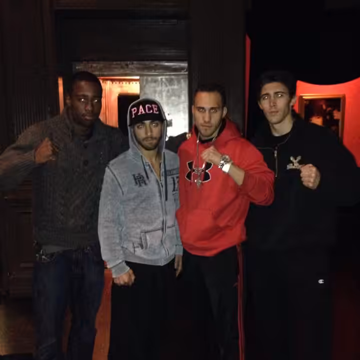 Four men MMA fighters outdoors at night in street clothes