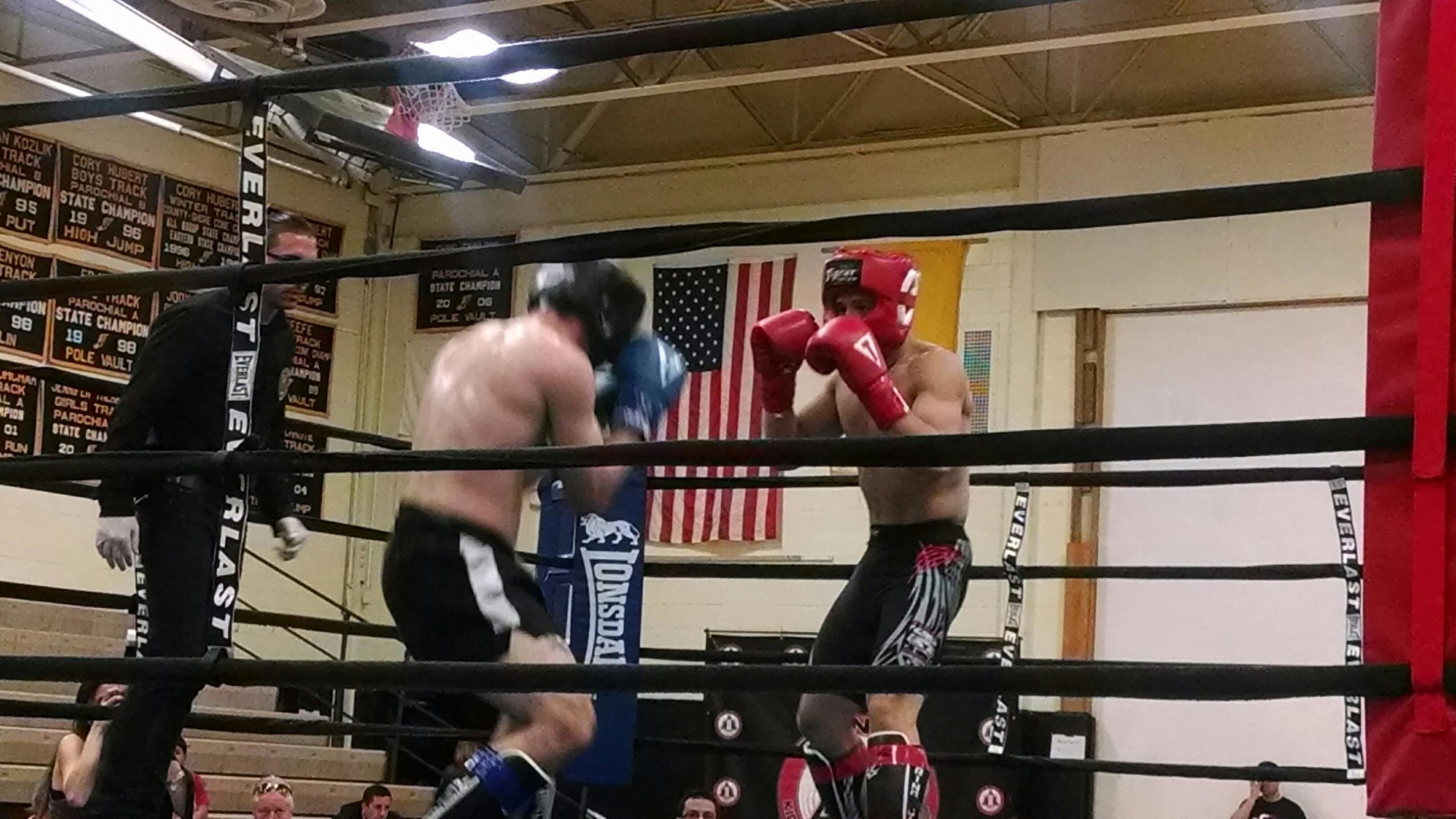 Two MMA fighters in action in octagon with US flag behind