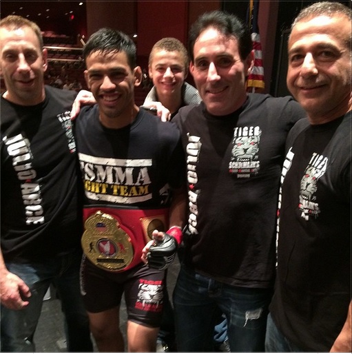 Four Tiger Schulmann's MMA fighters smiling with Championship Belt