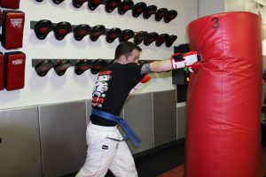 Man Punching a red bag at Tiger Schulmann's Smithtown