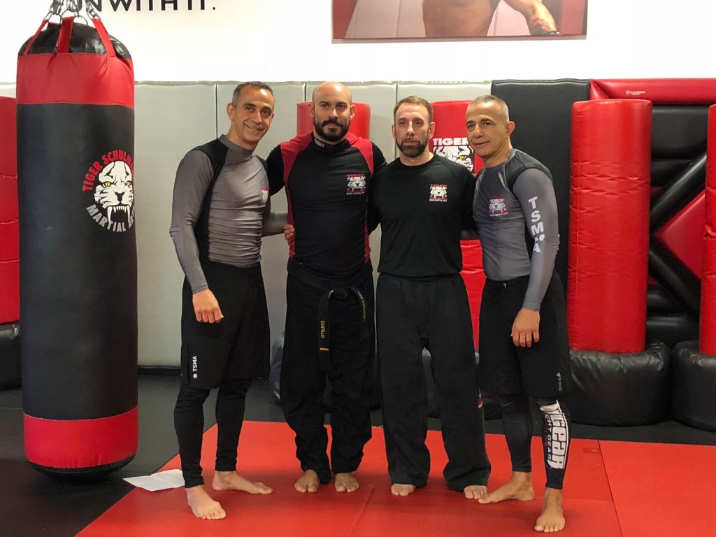 Four MMA fighters posing at Tiger Schulmann's gym