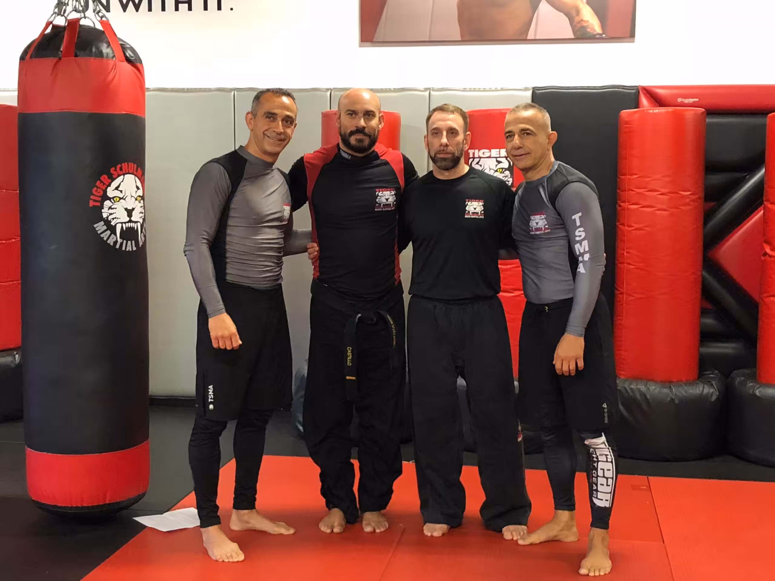 Four MMA fighters posing at Tiger Schulmann's gym