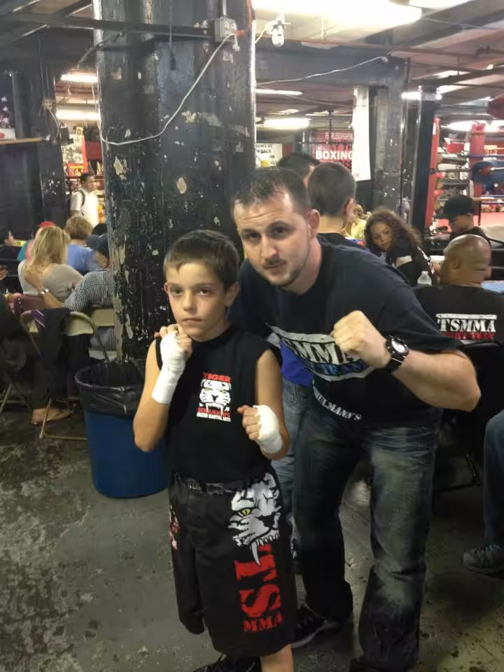 Adult and boy MMA fighters in a martial arts gym