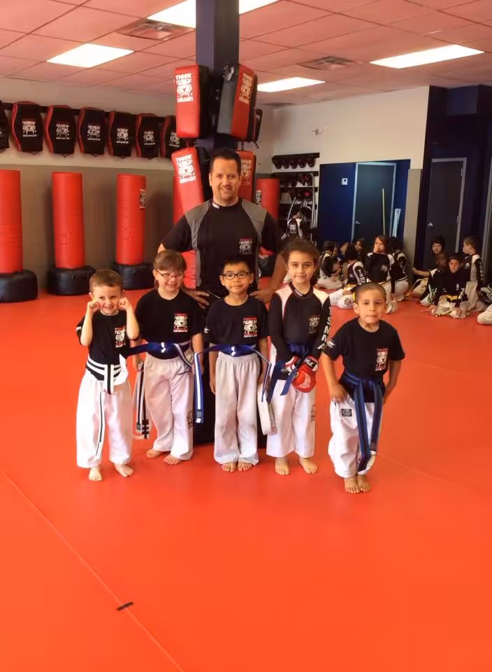 Five boy fighters and their instructor at red Tiger Schulmann's gym