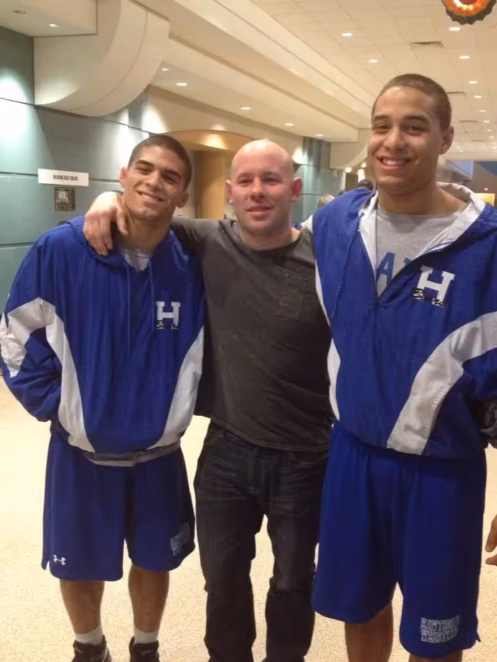 Wrestling coach with two of his high school students