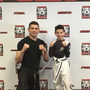 Martial arts instructor and a boy with fists up at Tiger Schulmann's in Abington