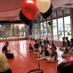 Kids sitting during their martial arts training with baloons beside them