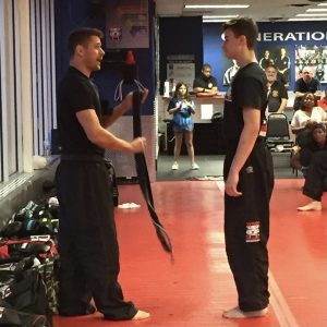 A boy receives his belt from his martial arts instructor in Abington
