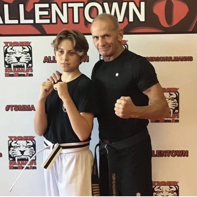 Shihan James Simpson and a boy fighter with their fists up