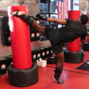 Kickboxer kicking a punching bag at Tiger Schulmann's Bayridge