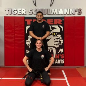 A girl fighter with her instructor standing behind at Tiger Schulmann's