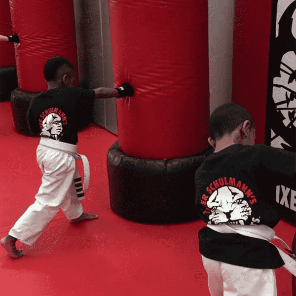 Two kids punching bags at martial arts training in Bethlehem