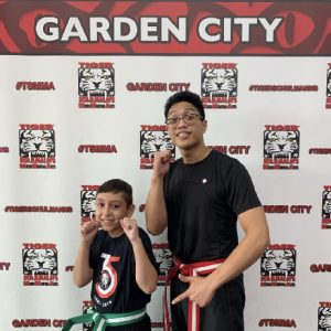 A boy and a man in fighting stance posing at Tiger Schulmann's Garden City